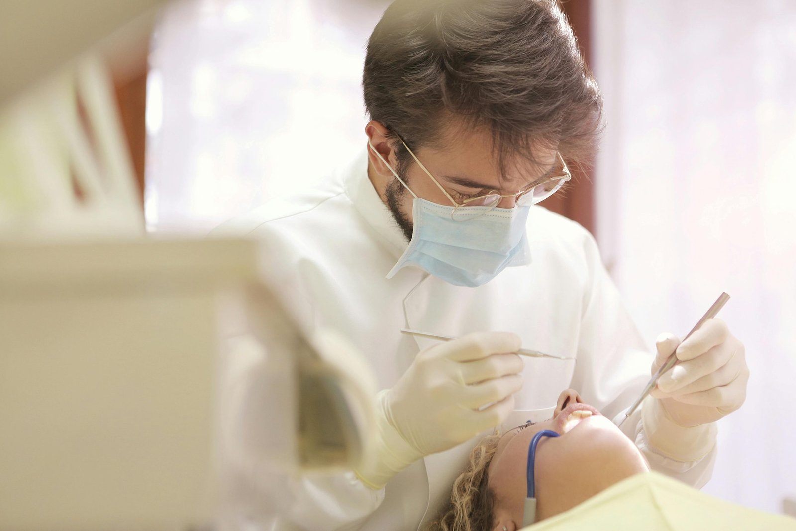 Dentist examining patient's teeth with dental tools